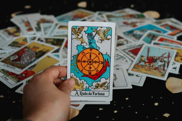 Reading Tarot Cards For Friends and Relatives - 3 Hand holding a tarot card with wheel of fortune.