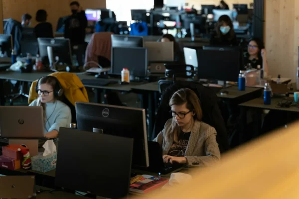 Tarot and AI: My Case For and Against AI - 21 a group of people working on laptops in an office